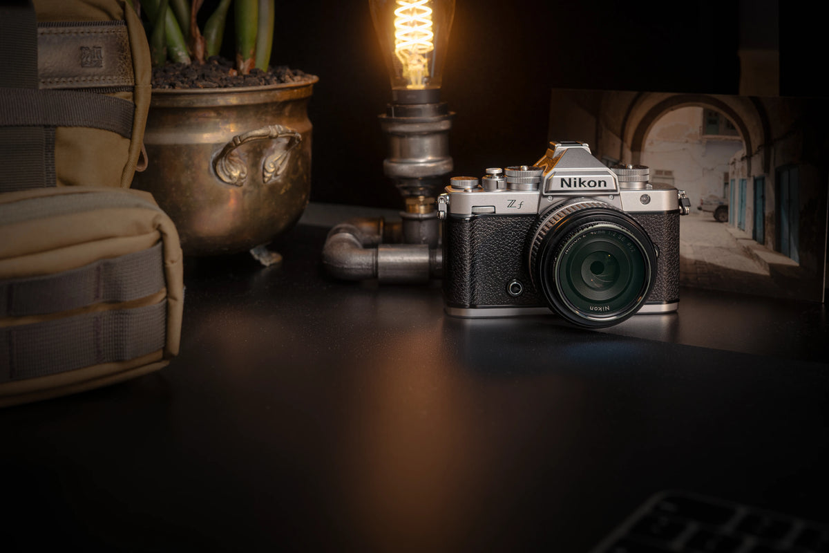 Nikon-Kamera, Lampe und Fotoprint in einem atmosphärischen Stillleben für Dustlight Archive.